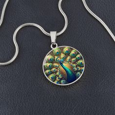 Admire the elegance of the Radiant Peacock Pendant Necklace, featuring a breathtaking stained glass style illustration of a peacock in full feather display. This intricate design showcases the peacock's vibrant plumage with stunning detail, capturing the essence of its regal beauty. Forged from premium surgical steel and available with a lavish 18k gold finish, this innovative jewelry boasts our exclusive design, handcrafted with care right here in the U.S.A by our dedicated team of skilled work Feather Display, Peacock Necklace, Peacock Pendant, Circle Pendant Necklace, Luxury Necklace, Glass Style, Working Moms, Circle Pendant, Intricate Design