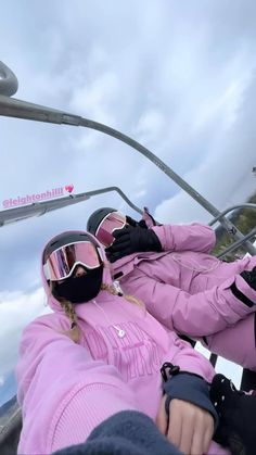 two people in pink jackets and goggles are taking a selfie