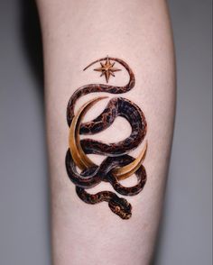 a tattoo on the leg of a person with a snake and moon design on it