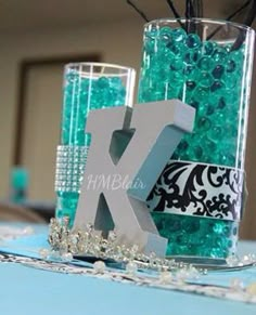 the letter k is placed in front of two glass vases with beads on them