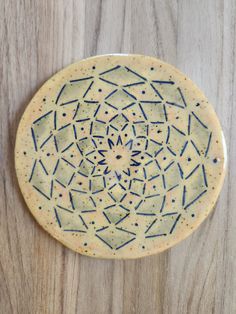 a white and blue plate sitting on top of a wooden table next to a wall