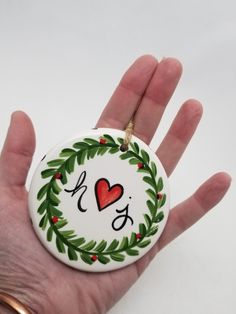 a hand holding a christmas ornament with the word mr and mrs on it