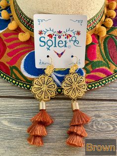 These Beautiful Mexican Earrings are made with the Mexican art form of twisting gold plated wires to create beautifully intricate works of art. The silk thread tassel adds that beautiful pop of color to any outfit. These earrings are handmade by Mexican Artisans. More colors available here: https://www.etsy.com/es/listing/974160414/aretes-mexicanos-de-filigrana-aretes?ref=listing_published_alert Mexican Earrings, Floral Filigree, Thread Earrings, Traditional Mexican, Mexican Dresses, Filigree Earrings, Mexican Art, Floral Earrings, Silk Thread