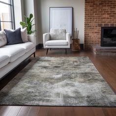 a living room with two white couches and a rug in front of a fireplace