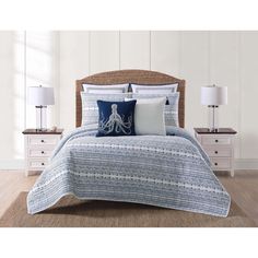 a bed with blue and white bedspread and pillows