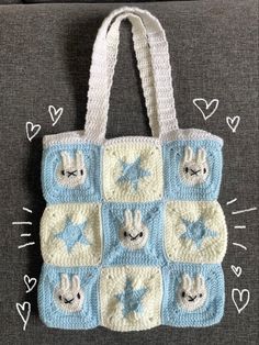 a crocheted tote bag with blue and white squares on the front, featuring rabbits