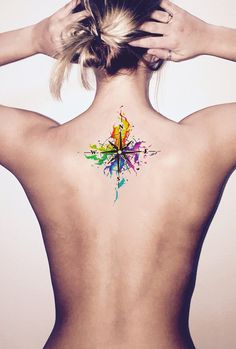 the back of a woman's neck with a colorful tattoo on it