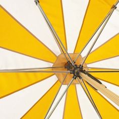 an overhead view of a yellow and white umbrella with wooden poles on the bottom half