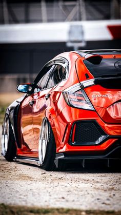 an orange sports car parked in front of a building