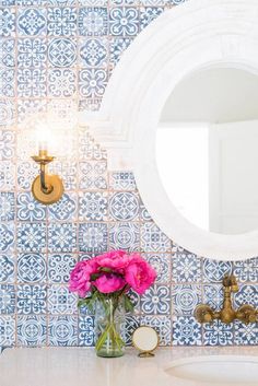 a white sink sitting under a bathroom mirror next to a wall mounted faucet