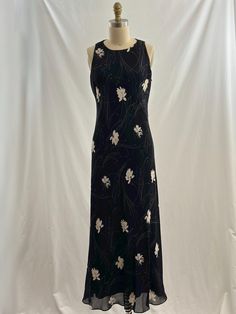 This vintage 90s maxi dresis a summer staple. On a navy background , it has an all over white and gray floral graphic in a sleeveless style. What a great dress to have in your closet! -Vintage 90s -White geay floral print -Dry clean only Measurements:   *Arm 7 1/2 opening inches *Bust 18 1/2 inches *Waist 17  inches *Hips 20 inches *Length 52 inches *Please note this item is pre-loved and there may be minor flaws. Not to worry if there is anything major we will let you know. --Please read shop p Black Sleeveless Vintage Maxi Dress, 90s Maxi Dress, Sundress Long, Long Floral Maxi Dress, Long Sundress, Floral Sundress, Summer Staples, Dress Medium, Grey Floral