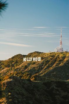 the hollywood sign on top of a hill with a cell phone tower in the background