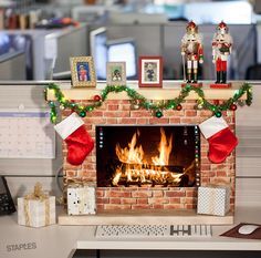 an office cubicle decorated for christmas with a fire place and decorations on the mantle