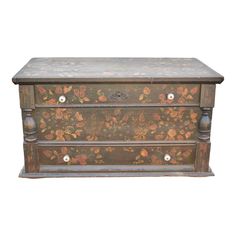 an old wooden chest with painted flowers on the front and drawers, against a white background