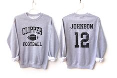 Customize this football shirt to meet your needs! Choose from short sleeve, long sleeve, hoodies, and crewneck sweatshirts and add your team/mascot and name/number! Other color options and styles are available. If you don't see what you're looking for send us a message! The shirts are a UNISEX retail fit - they are more of a relaxed fit and may run a little large on women and those with a smaller frame. Make sure to see the size and fit charts (last images) to confirm the best fit for you. We re Long Sleeve Tops For Football Season Fan Merchandise, Long Sleeve Tops For Football Season, Football Season Hoodie With Letter Print For Sports Events, Long Sleeve Team T-shirt For Football Season, School Spirit Long Sleeve T-shirt For Football Season, Collegiate Long Sleeve T-shirt For Football Season, Long Sleeve Hoodie With Letter Print For Football Season, Football Season School Spirit Long Sleeve Sweatshirt, Football Season Sports Fan Long Sleeve Hoodie