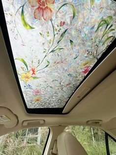 the interior of a car with flowers painted on the windshield and sunroofer