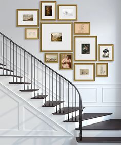 there is a staircase with many pictures on the wall and in front of it are some stairs