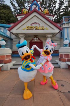 donald and daisy dancing in front of mickey's city hall at disneyland california adventure park