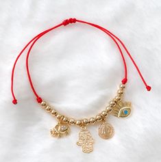 "Protection bracelet MATERIAL AND SIZE 18k gold filled balls 18k Gold filled charms (elephant, hamsa, St Benedict and eye) Adjustable 5.5\" up to 8.5\" Red or Black String If you have questions about the product, feel free to reach me out. Don't forget to check out my other items in the store: Https://www.etsy.com/shop/nyahwithlove" Adjustable Gold Evil Eye Bracelet, Adjustable Gold Evil Eye Symbolic Bracelet, Gold Adjustable Evil Eye Bracelet, Adjustable Gold Evil Eye Bracelet With Charms, Adjustable Gold Charm Bracelet With Evil Eye, Adjustable Gold Plated Evil Eye Jewelry, Gold Resizable Evil Eye Spiritual Bracelet, Gold Resizable Spiritual Evil Eye Bracelet, Gold Symbolic Bracelet With Evil Eye