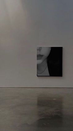 an empty room with two paintings on the wall and one is black and white in color