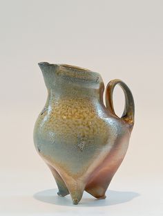 a ceramic vase sitting on top of a white table