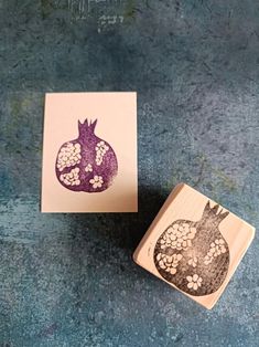 a stamp with a pomegranate on it sitting next to a piece of paper