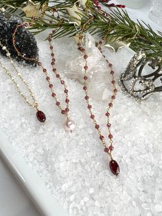 Buy individually or as a set & save!Choose from beautifully faceted Garnet rosary style chain, accented with lustrous Freshwater Pearls. Gorgeous classics with a bit of flair & color!Necklace: Rosary style faceted Garnets are accented with a lustrous 9 X 10mm Freshwater Pearl, which is hand wired to the center of the necklace. The Pearl pendant can be removed if you choose to wear them separately or the pendant on a different chain.Length: 16" with 2" extenderBracelet: Faceted Garnets are wire w Elegant Necklaces With Faceted Beads For Festive Occasions, Elegant Festive Necklaces With Faceted Beads, Elegant Dangle Beaded Necklaces With Faceted Beads, Elegant Dangle Beaded Necklace With Faceted Beads, Elegant Jewelry With Faceted Beads For Celebrations, Elegant Faceted Beads Jewelry For Celebration, Elegant Faceted Oval Bead Necklaces, Faceted Double Strand Beaded Necklace As Gift, Elegant Briolette Jewelry With Faceted Beads