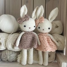 two crocheted stuffed animals sitting next to each other in front of yarn balls