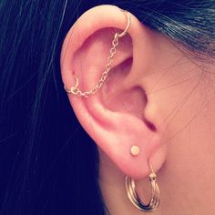 a close up of a person's ear with a chain attached to it