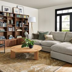 a living room with a couch, coffee table and bookshelf filled with books