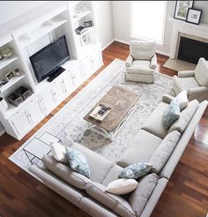 a living room filled with furniture and a flat screen tv on top of a wooden floor