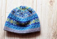 a blue and gray hat sitting on top of a wooden floor