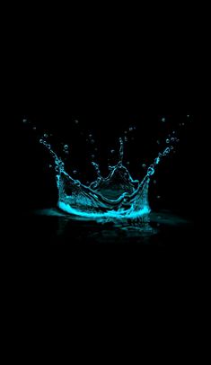 water splashing on top of a black surface with blue light coming from the bottom