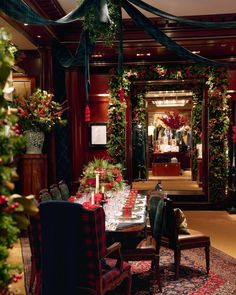 the dining room is decorated for christmas with red and green decorations, greenery and candles