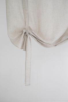 a white curtain with a tie hanging from it's side