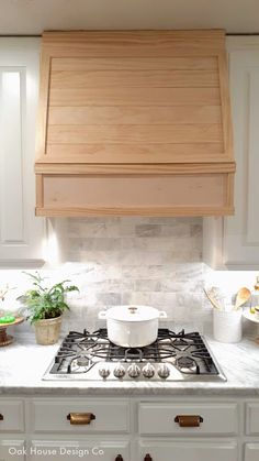 a stove top oven sitting inside of a kitchen next to white cabinets and counter tops