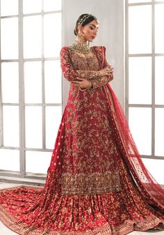 a woman in a red lehenga with gold embroidery on the neck and sleeves