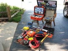 an assortment of tools are sitting on the sidewalk