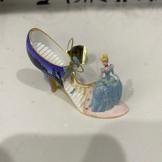 a pair of shoes that are sitting on top of a white table with a disney figurine next to it