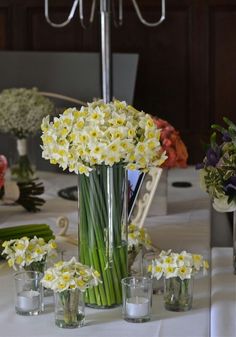 flowers are arranged in vases on a table