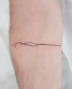 a man's arm with a small wave tattoo on the left side of his leg