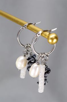 These unique pin hoop earrings from Estibela offer a perfect blend of sophistication and boldness, designed for those who value individuality and exclusive jewelry designs. Handcrafted from stainless steel, these earrings are both durable and elegantly shiny. The earrings feature a selection of exquisite pendants that add exceptional charm: a lustrous freshwater baroque pearl bead brings an element of elegance and romance, a quartz bead adds a vibrant touch of warmth and passion, and a bead made Handmade Small Hoop Pearl Earrings, Bohemian Dangle Earrings With Pearl Charm, White Metal Dangle Hoop Earrings, Metal Dangle Hoop Earrings With Pearl Charm, Pearl Charm Dangle Hoop Earrings, Handmade Pearl Dangle Hoop Earrings, Casual Festival, Chunky Bracelets, Ethnic Earrings