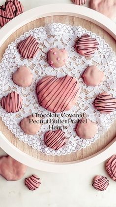 chocolate covered peanut butter heart shaped cookies on a lace doily with pink frosting