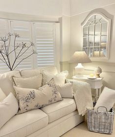 a living room filled with white furniture and pillows