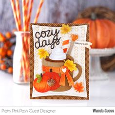 a close up of a card on a table with pumpkins and candles in the background