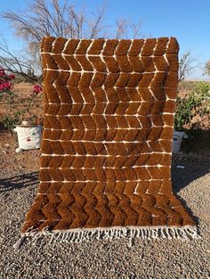 a brown and white blanket sitting on top of gravel