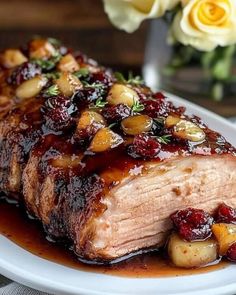 a piece of meat covered in cranberry sauce and garnished with potatoes