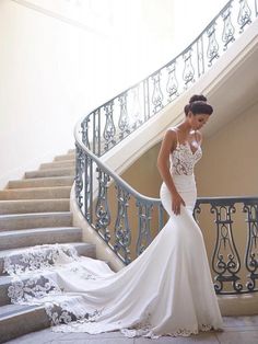 a woman in a wedding dress is standing on the stairs with her hand on her hip