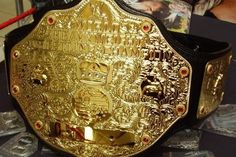 a gold wrestling belt sitting on top of a table