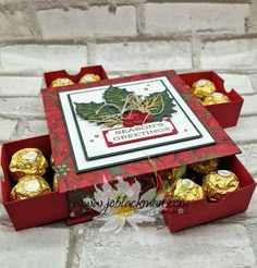 two red boxes filled with chocolates on top of a white tile floor next to a brick wall